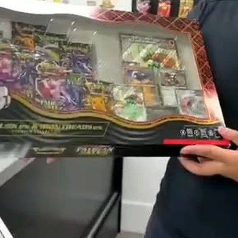 An open Pokémon collection box held up in the shop
